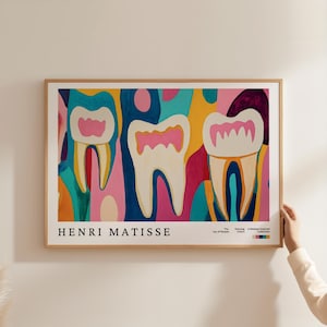 Puede incluir: Una impresión artística enmarcada con un diseño abstracto de tres dientes. Los dientes son blancos con encías rosas, sobre un fondo vibrante de azules, amarillos y rosas. El nombre del artista, Henri Matisse, está impreso en la parte inferior.
