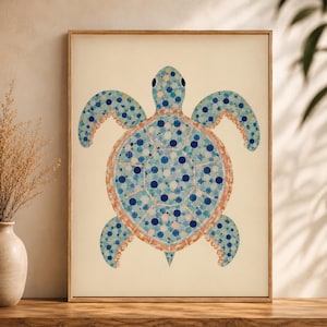 May include: A framed wall art print featuring a sea turtle illustration composed of various shades of blue and white circular dots. The turtle has a light orange outline around its shell and flippers, set against a solid cream-coloured background.