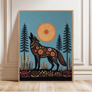 May include: A rectangular wall art print featuring a black wolf silhouette filled with colorful floral patterns, howling toward a large orange sun in a blue sky. The scene includes black pine trees and a foreground of small flowers and plants.