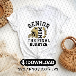 Op de afbeelding: Wit T-shirt met een zwart-gouden afbeelding. De afbeelding bevat de woorden "SENIOR MOM" boven een footballhelm en football, en "THE FINAL QUARTER" eronder. Het shirt heeft ook een downloadknop.
