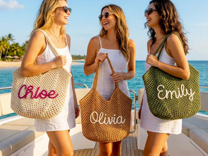 K&ouml;nnte beinhalten: Drei Frauen auf einem Boot mit personalisierten H&auml;keltaschen. Die Taschen sind beige, braun und olivgr&uuml;n, mit den Namen "Chloe", "Olivia" und "Emily". Die Frauen tragen Sonnenbrillen und wei&szlig;e Kleider und l&auml;cheln in die Kamera.