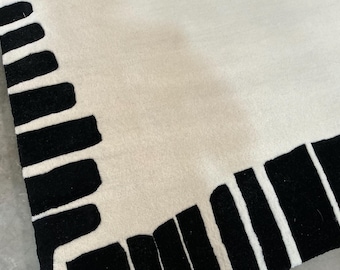 Alfombra marroquí tejida a mano: alfombra de lana color marfil con borde abstracto en color carbón | Minimalista y moderno. Contáctanos para solicitudes personalizadas.