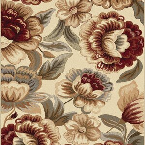 Puede incluir: Una alfombra floral con fondo crema y grandes flores detalladas en tonos burdeos, marr&oacute;n y beige. El dise&ntilde;o incluye hojas estilizadas en gris y marr&oacute;n, creando un aspecto cl&aacute;sico y elegante para cualquier espacio.