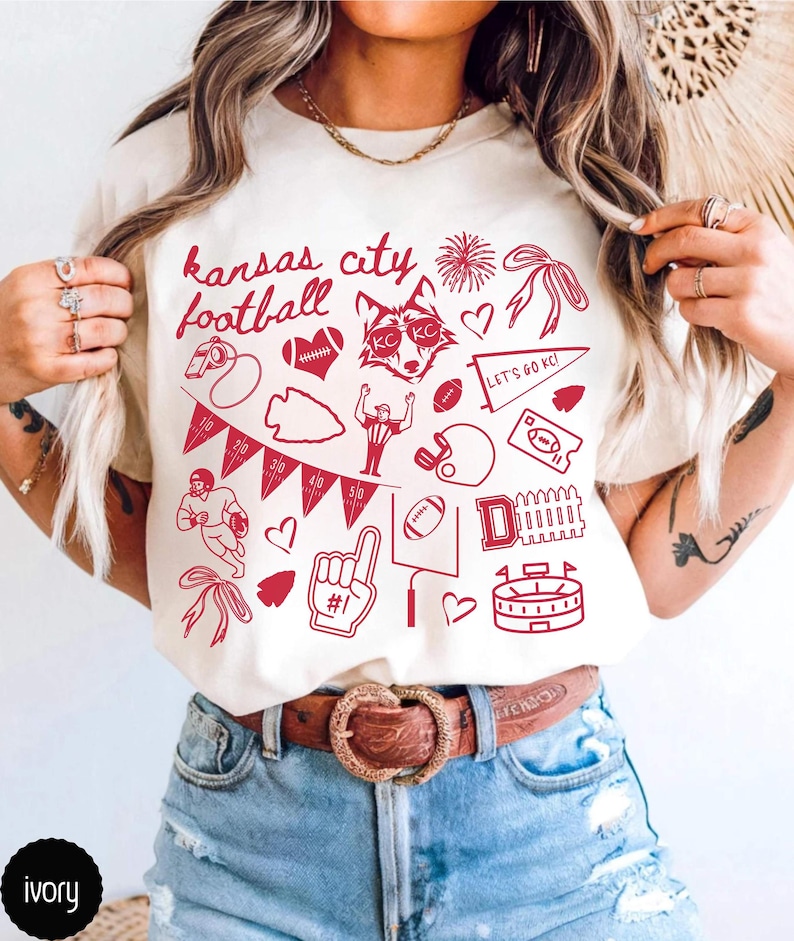 model wearing ivory comfort colors shirt that has doodle football designs and says kansas city football