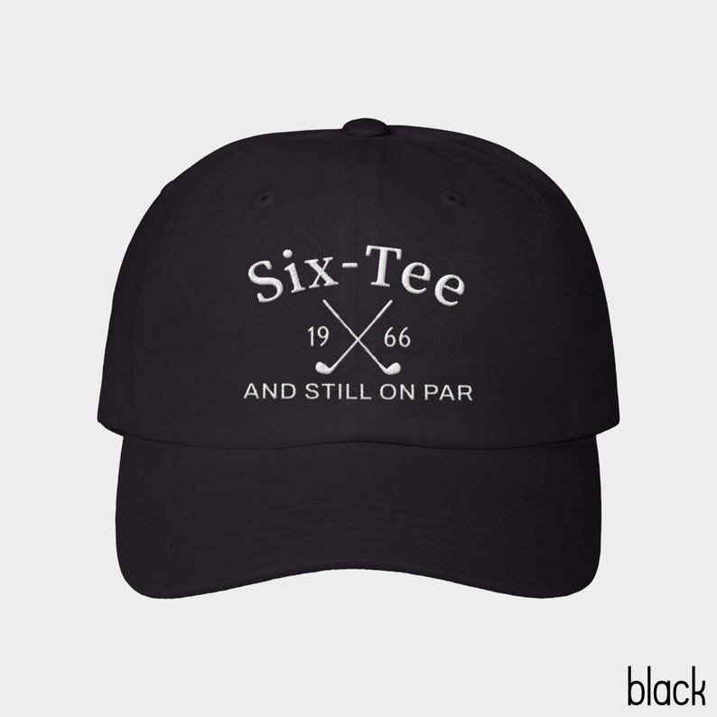 May include: A black baseball cap featuring white embroidered text that reads Six-Tee 19 66 AND STILL ON PAR, with a graphic of two crossed golf clubs positioned between the numbers 19 and 66 on the front panel of the hat.