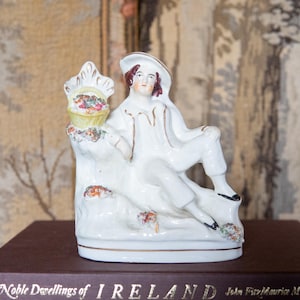 Victorian antique Staffordshire figurine. Young boy leaning on flower basket