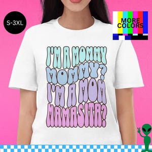 Camiseta Mommy Mamasita, fãs de Huda e Nic, homenagem a reality show, conversa sobre Unhinged Island, citação de Love Mom, apresentação icônica da cultura pop