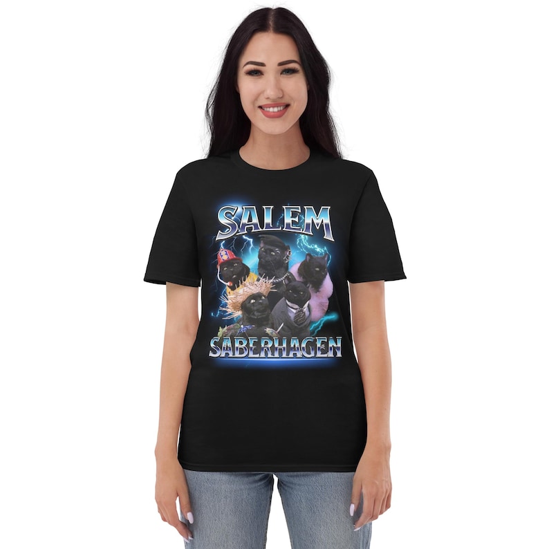 May include: Black t-shirt with a graphic of a group of black cats wearing costumes and the text "Salem Saberhagen".