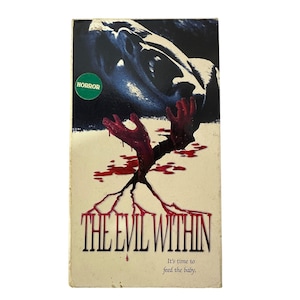 May include: A vintage VHS tape for the horror film "The Evil Within." The cover features a dark, ominous image of a face and bloody hands emerging from a surface. The title is in a bold, red font, with the tagline "It's time to feed the baby."