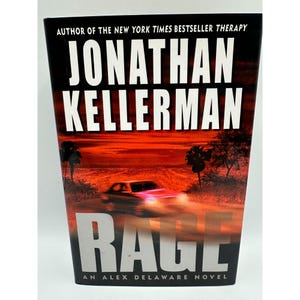 Könnte beinhalten: Buchcover von Jonathan Kellermans "Rage", mit dem Namen des Autors in Weiß und dem Titel in Rot. Der Hintergrund zeigt ein verschwommenes Bild eines Autos auf einer Straße, vor einem feurigen roten Himmel, mit dem Text "An Alex Delaware Novel".