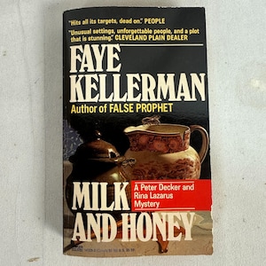Puede incluir: Un libro de bolsillo titulado "Milk and Honey" de Faye Kellerman. La portada presenta un fondo oscuro con el título en letras blancas grandes y una ilustración de una jarra y un tarro. El libro es un misterio de Peter Decker y Rina Lazarus.