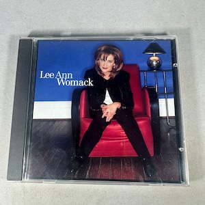 May include: A CD case featuring Lee Ann Womack. The cover art shows Womack seated in a red chair against a blue wall. The artist's name is displayed in white text on the upper left.