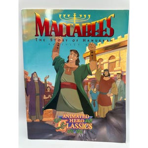 May include: A colorful book cover for "Maccabees: The Story of Hanukkah Activity Book." The cover features an animated illustration of a man in green clothing with his arms raised, surrounded by other figures. The title is in large red letters.