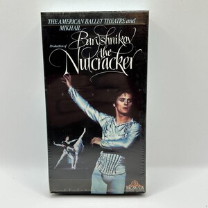 May include: A VHS tape for "The Nutcracker" ballet production featuring Mikhail Baryshnikov. The cover is black with white text and a photo of a male ballet dancer in a light blue costume. The MGM/UA logo is in the bottom right corner.