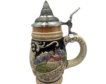 以下が含まれることがあります： 山と建物が描かれた、詳細なレリーフデザインのセラミックビールジョッキ。 ジョッキにはヒンジ付きの金属製の蓋とハンドルが付いています。 色はベージュ、黒、茶色、緑、銀色です。