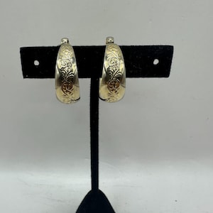 May include: A white ceramic mug with a black handle and the text "But First, Coffee" in a black, bold font. The mug is on a white surface.