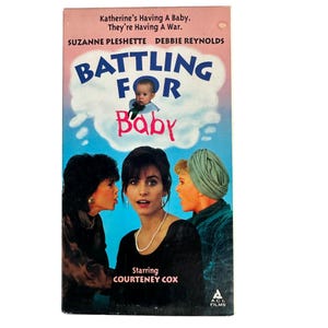 May include: A VHS tape for the movie "Battling for Baby" with Suzanne Pleshette, Debbie Reynolds, and Courteney Cox. The cover features a baby in a cloud, the title in blue and pink, and three women. The ACI Films logo is at the bottom.