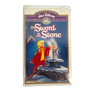 May include: A VHS tape of Disney's "The Sword in the Stone" from the Masterpiece Collection. The cover features an illustration of a young man in red robes pulling a sword from a stone, with the title in large, stylized lettering.