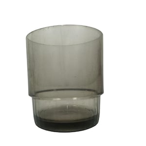 May include: A cylindrical glass tumbler with a translucent smoky gray tint. The vessel features a smooth, wide upper section that transitions into a slightly narrower, ribbed base with vertical indentations, creating a distinct tiered profile.