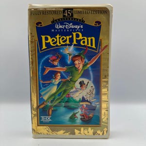 May include: A VHS tape of Walt Disney's animated film "Peter Pan." The cover features Peter Pan, Tinkerbell, Wendy, and Captain Hook. The tape is a 45th Anniversary Limited Edition, fully restored.