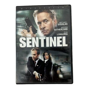 May include: A DVD case for the film The Sentinel featuring Michael Douglas, Kiefer Sutherland, and Eva Longoria. The cover art displays the three actors, with Douglas holding a handgun, alongside the movie title in large white capital letters.