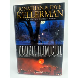 May include: A hardcover book titled "Double Homicide" by Jonathan & Faye Kellerman. The cover features a nighttime scene with a full moon, trees, and city lights. The book's title is in large white letters, with the authors' names in gold.