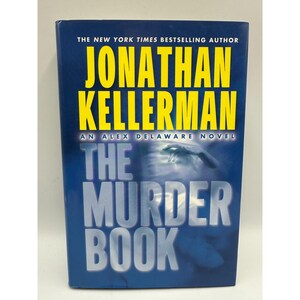 May include: A hardcover book titled "The Murder Book" by Jonathan Kellerman. The cover is dark blue with yellow text. The author's name is prominently displayed at the top, with the title in large, bold letters below. An Alex Delaware novel.
