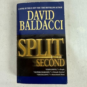 May include: A novel by David Baldacci, titled "Split Second". The book cover is blue with gold lettering. The cover includes quotes from People, Orlando Sentinel, and Associated Press.