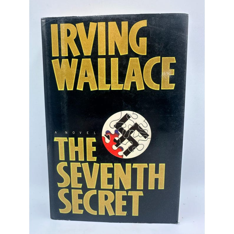 May include: A hardcover book titled "The Seventh Secret" by Irving Wallace. The cover is black with gold lettering. A circular graphic features a swastika puzzle piece with red and white accents.