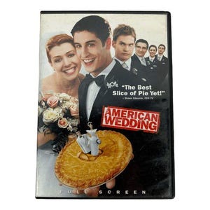 Peut inclure: Un boîtier DVD du film American Wedding montrant une distribution d'acteurs en tenue de cérémonie. La couverture présente une figurine de gâteau de mariage sur une tarte dorée, avec le texte The Best Slice of Pie Yet et American Wedding.