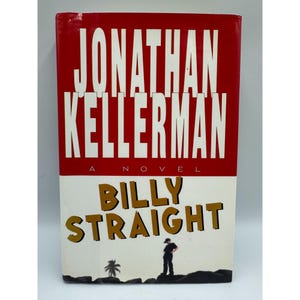 May include: A hardcover book titled "Billy Straight" by Jonathan Kellerman. The book cover features a red top section with the author's name in large white letters. The bottom half is white with the title in gold letters and a silhouette of a person.