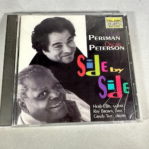 May include: A CD case with a black cover, featuring two men in black and white. The title "Side by Side" is in colorful letters. The names of the musicians, Itzhak Perlman and Oscar Peterson, are also displayed on the cover.