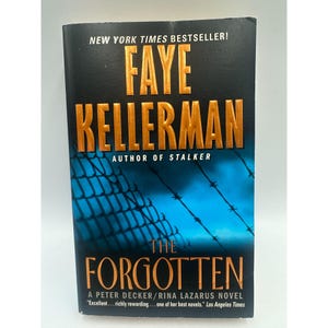 May include: A paperback book titled "The Forgotten" by Faye Kellerman. The cover features the author's name in gold lettering, with the title in a bold font. The background shows a blue sky with barbed wire.