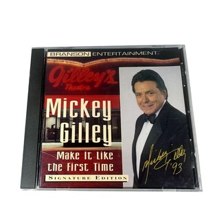 May include: A CD case featuring Mickey Gilley's "Make It Like the First Time" album, a Signature Edition. The cover displays Gilley's Theatre, the artist's name, and a photo of Gilley in a tuxedo. The CD case is in a clear plastic sleeve.