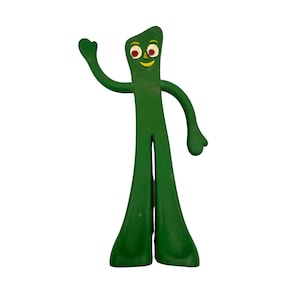 May include: A green, stylized figure with a rectangular body, arms, and legs. The figure has a smiling face with red eyes and a yellow mouth. One arm is raised in a waving gesture. The figure is standing on a white background.