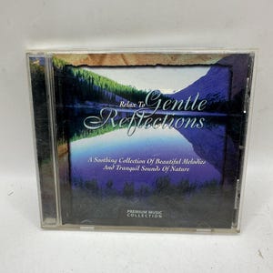 May include: A CD case for "Relax to Gentle Reflections" with a landscape image of a lake and mountains. The text on the cover reads "A Soothing Collection Of Beautiful Melodies And Tranquil Sounds Of Nature." The album title is also visible.