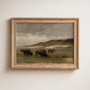 Può includere: Dipinto paesaggistico incorniciato con un branco di bisonti al pascolo in un campo erboso sotto un cielo nuvoloso. L'opera d'arte è in una cornice di legno rustico, che aggiunge un tocco vintage.