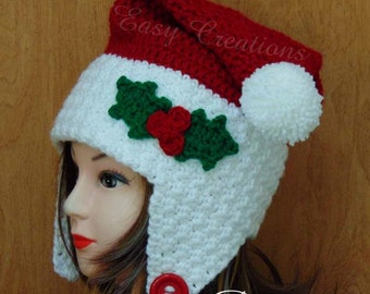 May include: A red and white crocheted Christmas hat with a holly and berry design. The hat has a red pom-pom and a red button. The text "Easy Creations" and "Pattern" are visible on the hat.