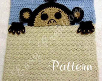 May include: Crocheted baby blanket featuring a monkey design. The blanket has a light blue top section and a tan bottom section. The monkey's face, ears, and hands are black and tan. The word "Pattern" is written in white.