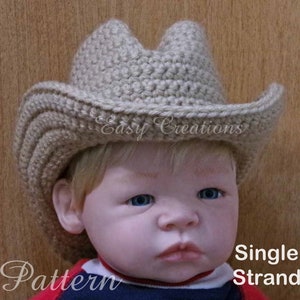 May include: A tan crocheted cowboy hat made with single strand yarn. The hat is worn by a baby. The text "Easy Creations" is visible on the hat.