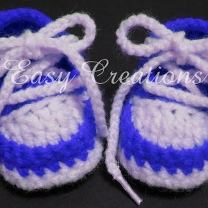 May include: A pair of crocheted baby booties in purple and white with white laces. The booties have a blue and white striped pattern.