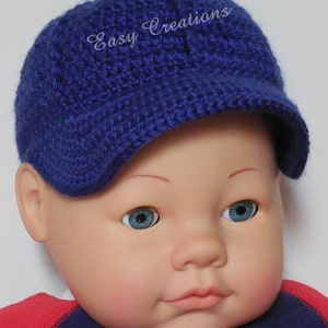 Puede incluir: Un gorro de beb&eacute; de crochet azul con visera y el texto "Easy Creations" bordado en la parte delantera.