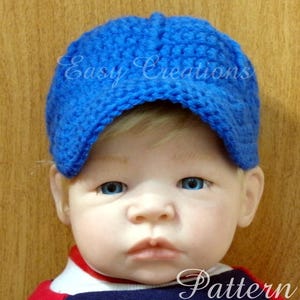 May include: A bright blue crocheted baseball cap with a textured yarn finish. The cap features a rounded crown and a short, curved brim. The text Easy Creations Pattern is overlaid on the image in a white script font across the cap and bottom.