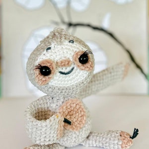 Può includere: Bambola di bradipo all'uncinetto fatta a mano, nei toni del grigio e del rosa. Il bradipo ha occhi neri con lunghe ciglia, una bocca sorridente e le braccia tese. Il peluche è realizzato con un filato morbido e strutturato.