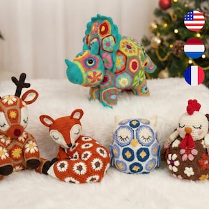 Peut inclure: Collection de jouets crochetés faits à la main, dont un renne, un renard, un hibou, une dinde et un dinosaure Triceratops. Chaque animal est fait de fil coloré avec des motifs floraux et des yeux fermés.
