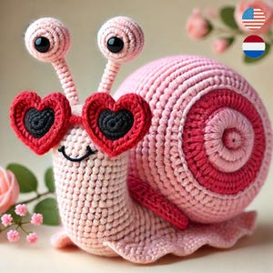 Peut inclure: Un escargot en crochet rose portant des lunettes en forme de cœur. L'escargot a une coquille rose et rouge avec un motif en spirale.