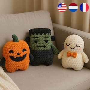 May include: Three handmade crochet Halloween decorations: an orange jack-o'-lantern, a green Frankenstein's monster, and a white ghost with an orange bow tie. The plush toys are sitting on a beige couch.
