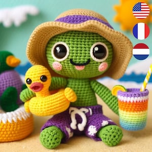 Peut inclure: Une tortue en crochet vert portant un chapeau de paille et un short de bain violet tient un canard en caoutchouc jaune avec une bouée. La tortue est assise sur une plage de sable avec une tasse arc-en-ciel en crochet et un canard vert en crochet en arrière-plan.