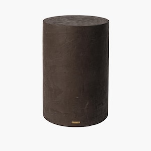 May include: A dark brown, cylindrical pedestal with a textured surface. The solid, round column has a flat top and bottom. A small, rectangular gold label is affixed near the base. The pedestal is suitable for displaying decorative items.