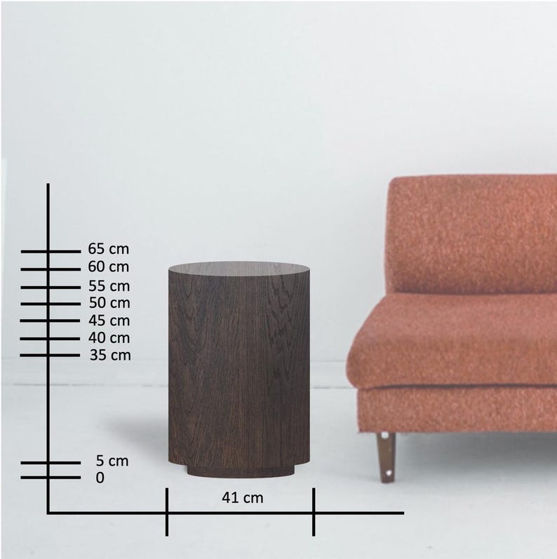 May include: A dark brown, cylindrical side table with a textured wood grain finish. The table is 25.6 inches tall and 16.1 inches wide. It has a slightly wider base and is positioned next to a rust-colored sofa.